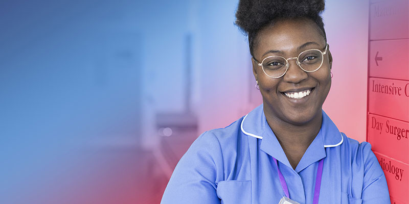 An NHS nurse in a hospital smiles warmly