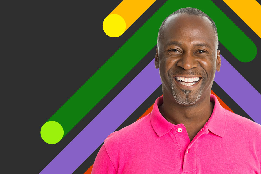 Man smiling in front of a colourful background