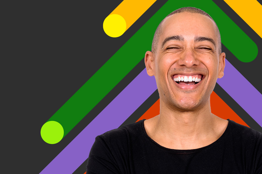 Man smiling in front of a colourful background