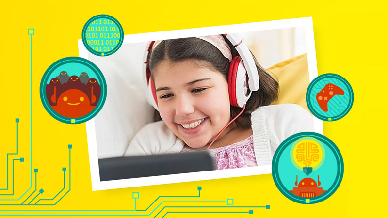 Child wearing headphones using a laptop and smiling